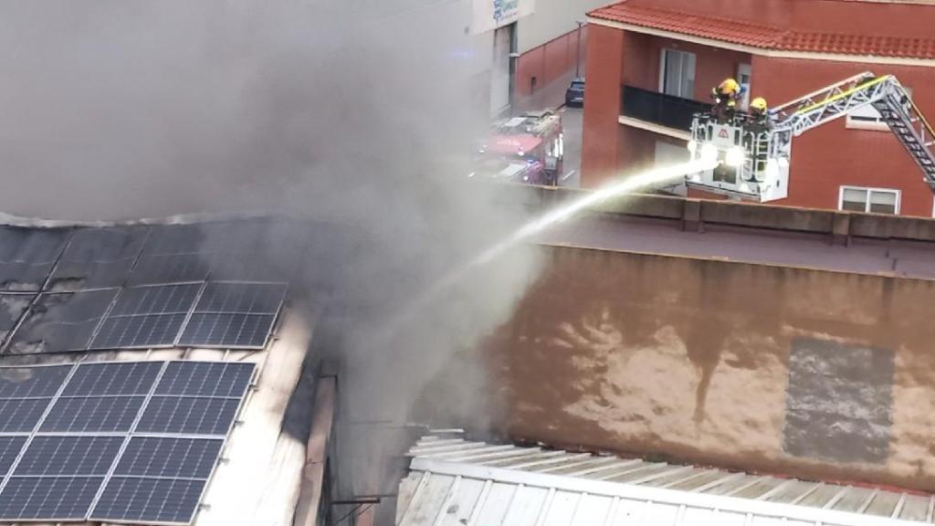 Varios bomberos trabajan en la extinción del incendio de una nave industrial en Reus