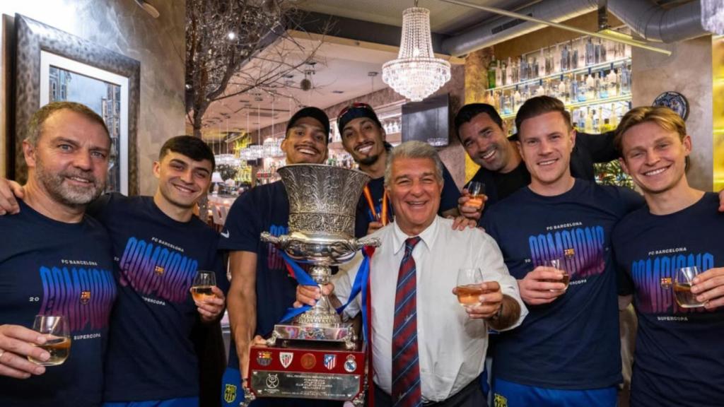 Joan Laporta, Hansi Flick, Deco y los jugadores del Barça posan con la Supercopa en un fotomontaje con el Restaurante Gaudim de fondo