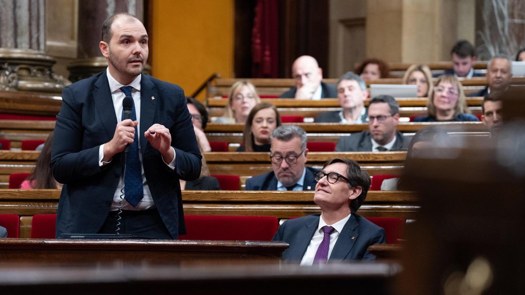 El conseller de Presidencia, Albert Dalmau, de pie junto al presidente de la Generalitat, Salvador Illa, durante una sesión de control al Govern en el Parlament, a 26 de febrero de 2025