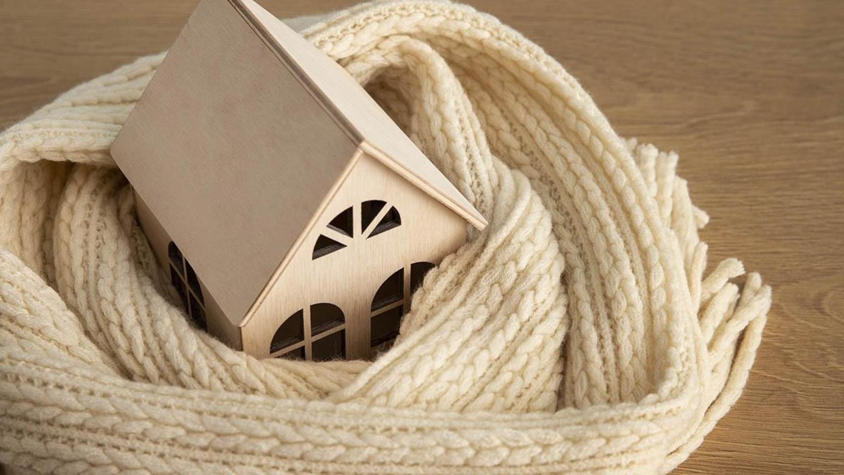 Pequeña casa de madera rodeada por una bufanda