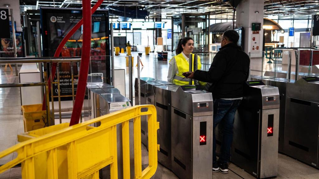 Un usuario de Rodalies pregunta a una trabajadora de Renfe