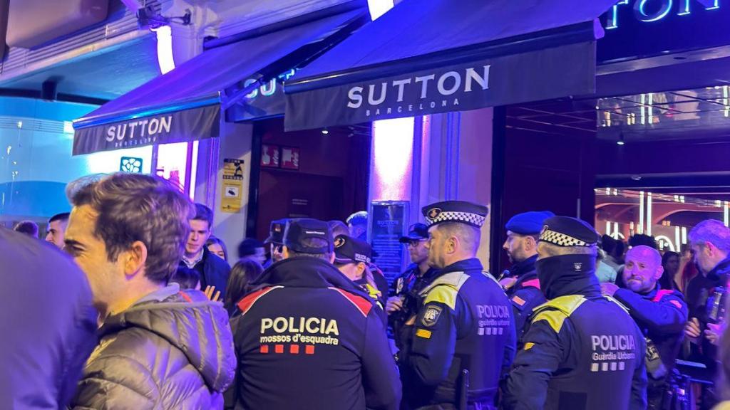 Agentes de los Mossos d'Esquadra y la Guardia Urbana delante de Sutton, Barcelona, tras el incidente