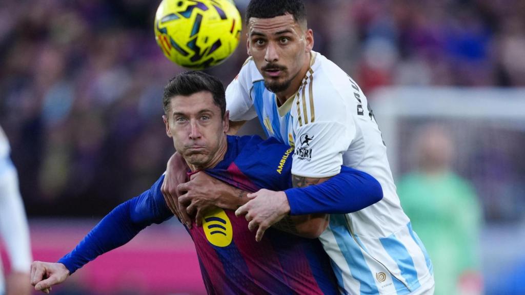 Robert Lewandowski forcejea con un rival en el Barça-Real Oviedo de la Liga