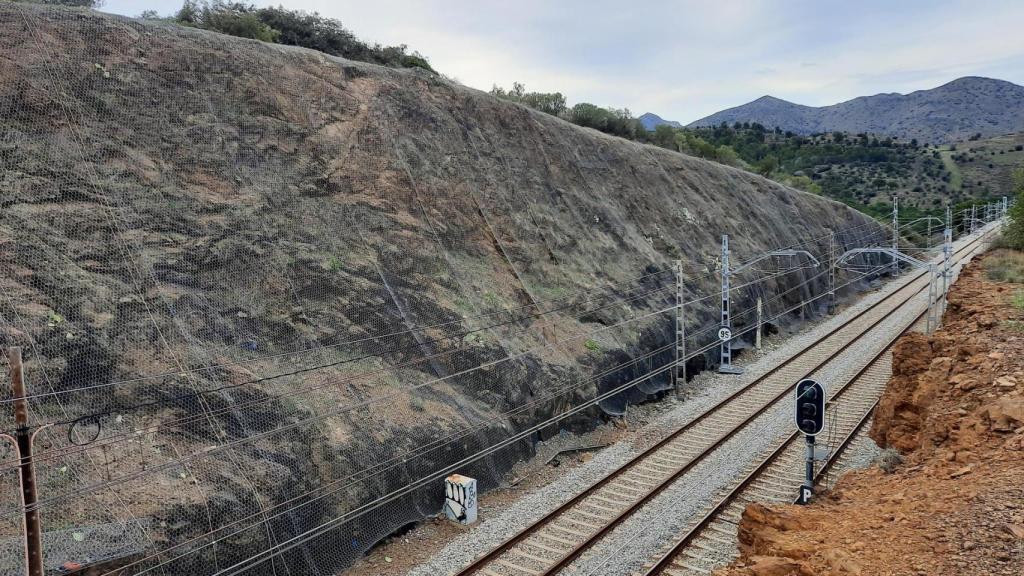 Vista de una intervención de colocación de malla protectora en un tramo de vía férrea entre Figueres y Portbou (Girona), uno de los 31 puntos de la red ferroviaria de Cataluña en los que Adif ha trabajado en Cataluña