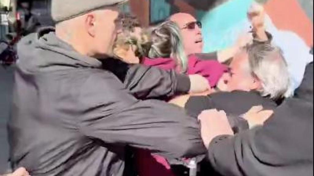 Un grupo de personas, increpando a una carpa de simpatizantes Vox en Montcada i Reixac