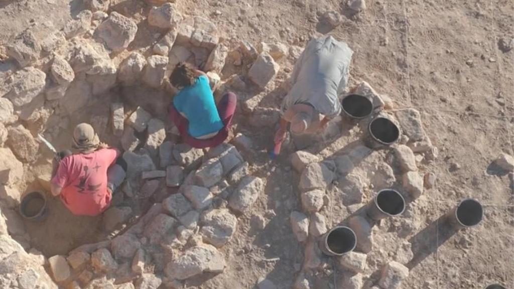 Fotomontaje con una fotografía de una excavación arqueológica y el loco del sindicato CNT