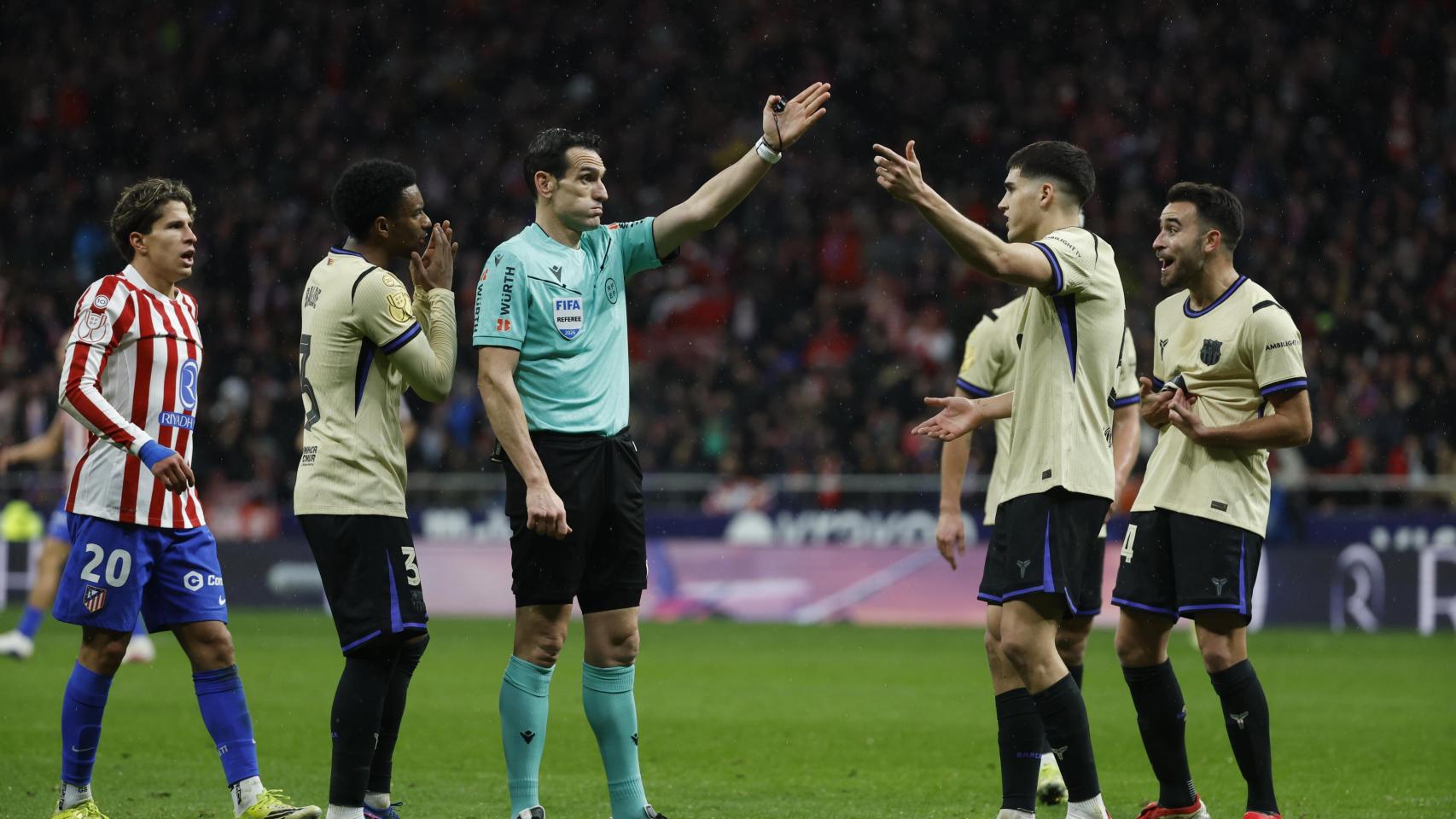 Los jugadores del Barça protestan una falta al árbitro Juan Martínez en el partido contra el Atlético de Madrid