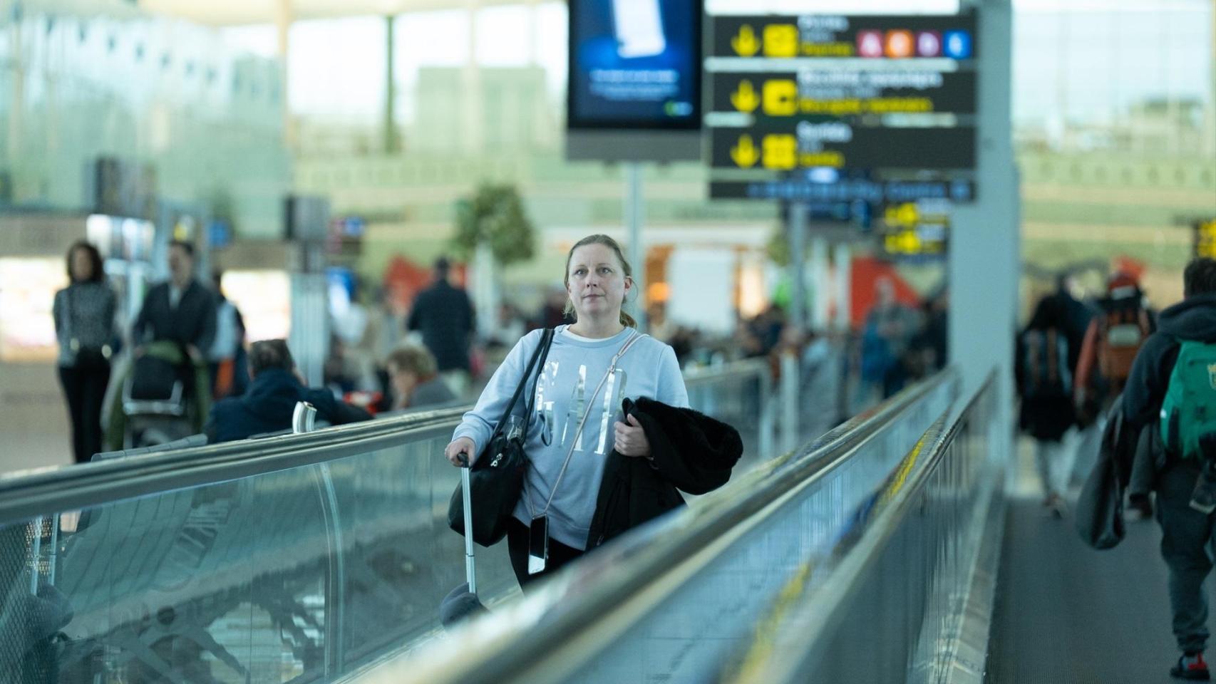 Una mujer camina con su maleta en una cita en el aeropuerto de El Prat (archivo)