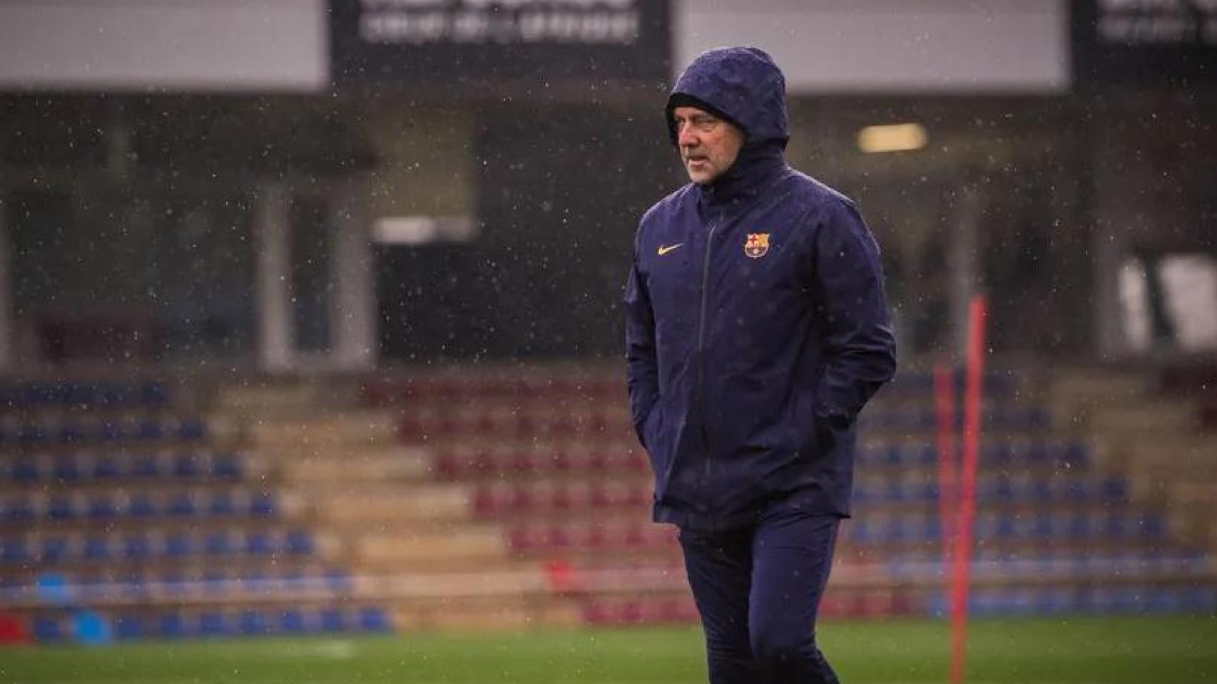 Hansi Flick, bajo la lluvia, durante un entrenamiento del Barça