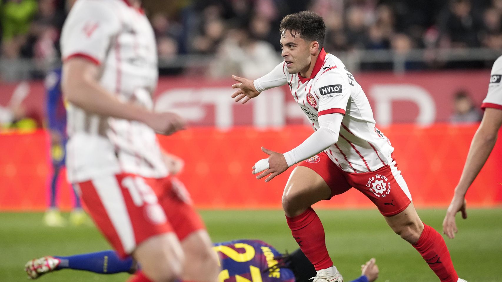 Fran Beltrán celebra su gol mientras Jules Koundé yace sobre el césped tras recibir un pisotón de Claudio Echeverri