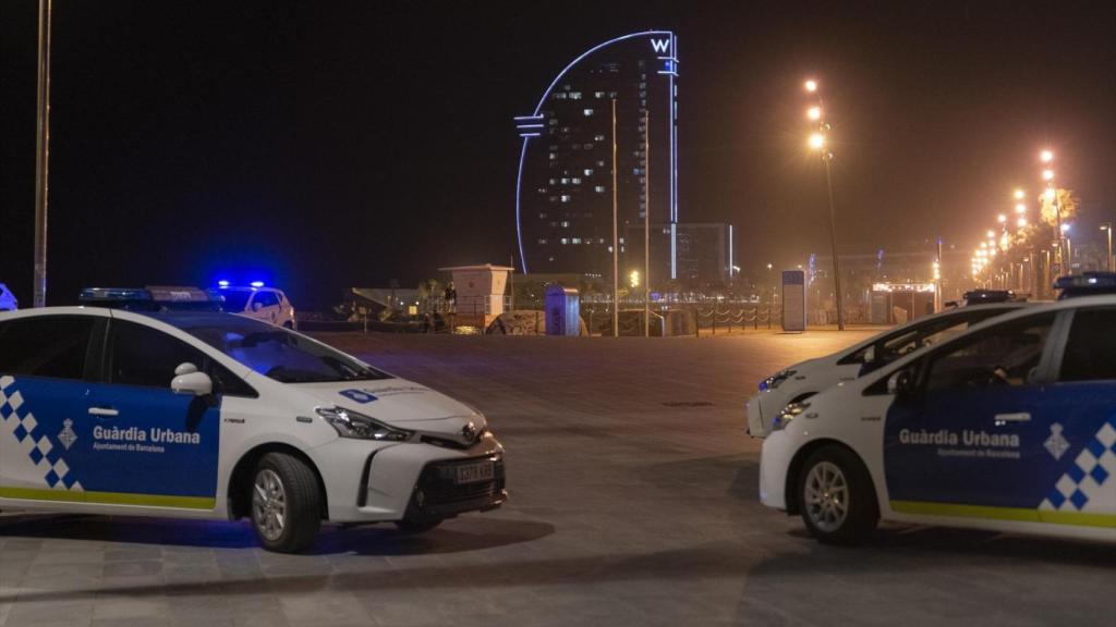 Dos coches de la Guardia Urbana aparcados en la playa de la Barceloneta