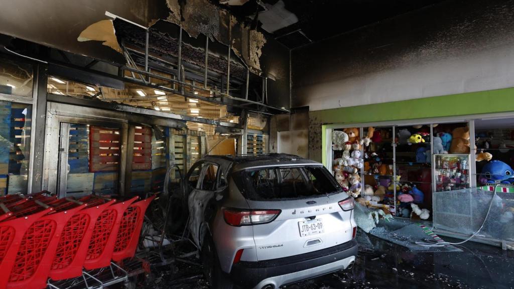 Fotografía de un vehículo incendiado en un centro comercial por presuntos integrantes del crimen organizado este domingo, tras el abatimiento de Nemesio Oseguera Cervantes, alias El Mencho, líder del Cártel Jalisco Nueva Generación (CJNG), en Guadalajara (México)