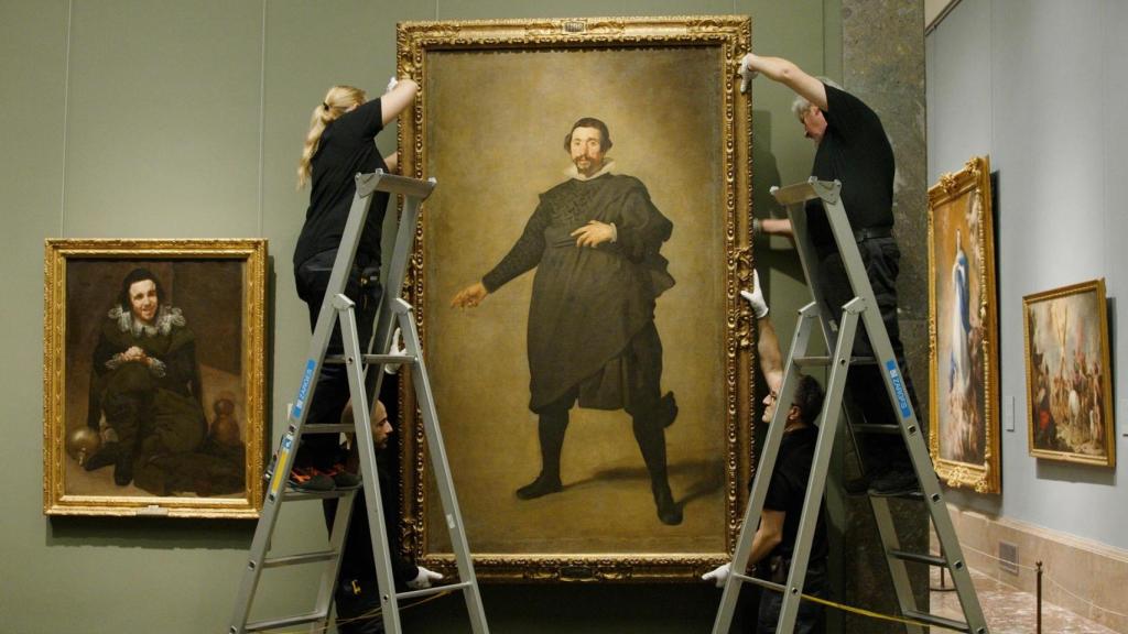 Dos operarios retiran para su restauración el retrato de Pablo de Valladolid de la sala 15 del edificio Villanueva del Museo del Prado.