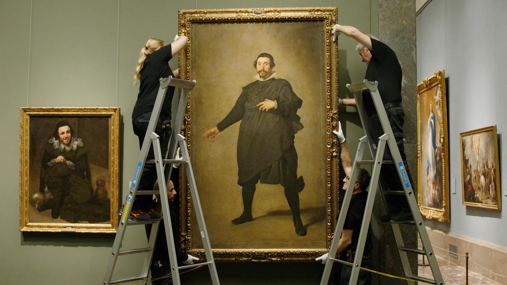 Dos operarios retiran para su restauración el retrato de Pablo de Valladolid de la sala 15 del edificio Villanueva del Museo del Prado.