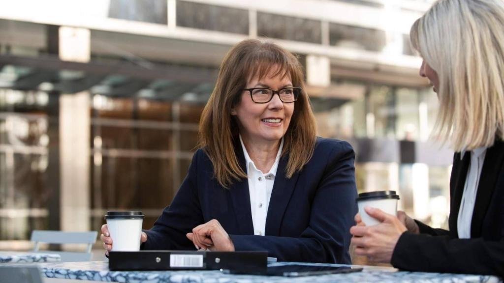 Mujeres profesionales conversan mientras toman un café