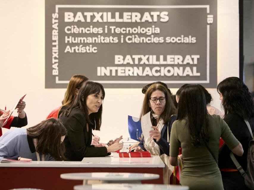 Varios estudiantes piden asesoramiento en un stand del Salón de l'Ensenyament