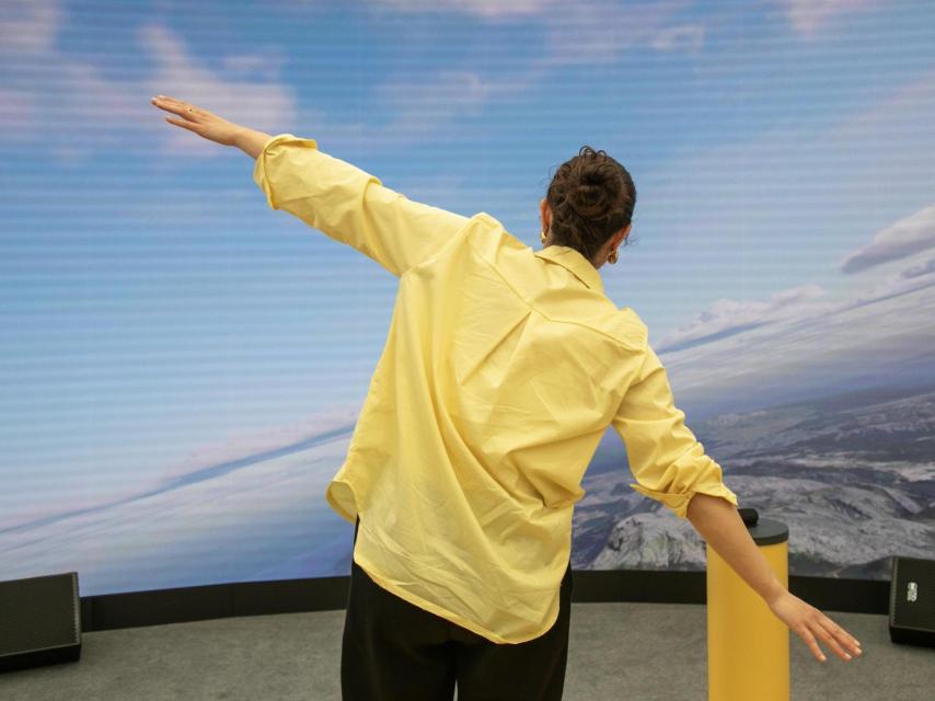 Una persona practica en el simulador de vuelo en el stand de Vueling en el MWC26