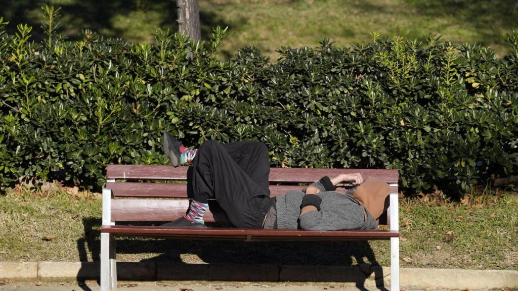 Una persona sense llar en un parc de Barcelona.
