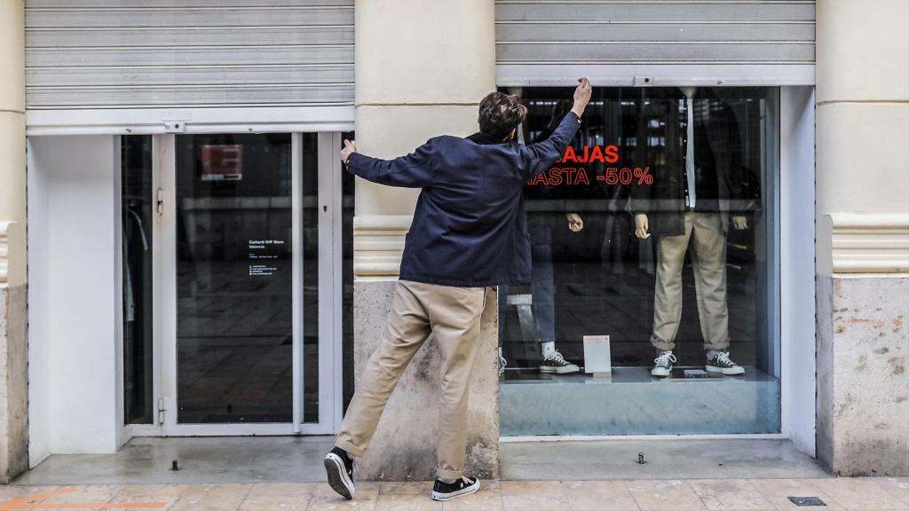 El trabajador de un comercio cierra su establecimiento.