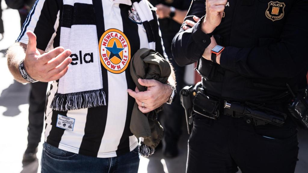 Un aficionat del Newcastle preguntant a un agent dels Mossos d'Esquadra