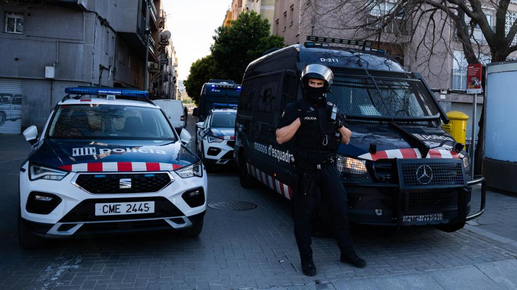 Furgones y coches de los Mossos d'Esquadra, junto con un agente de la Brimo, durante el despliegue del 'Plan Kanpai' en Montcada i Reixac