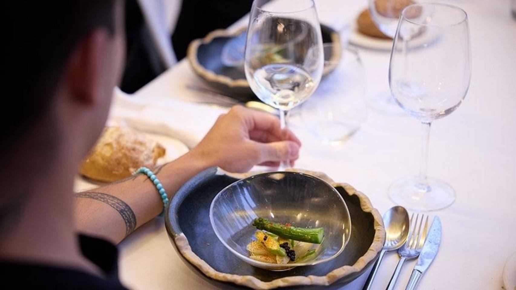 Un comensal con una copa de vino vacía