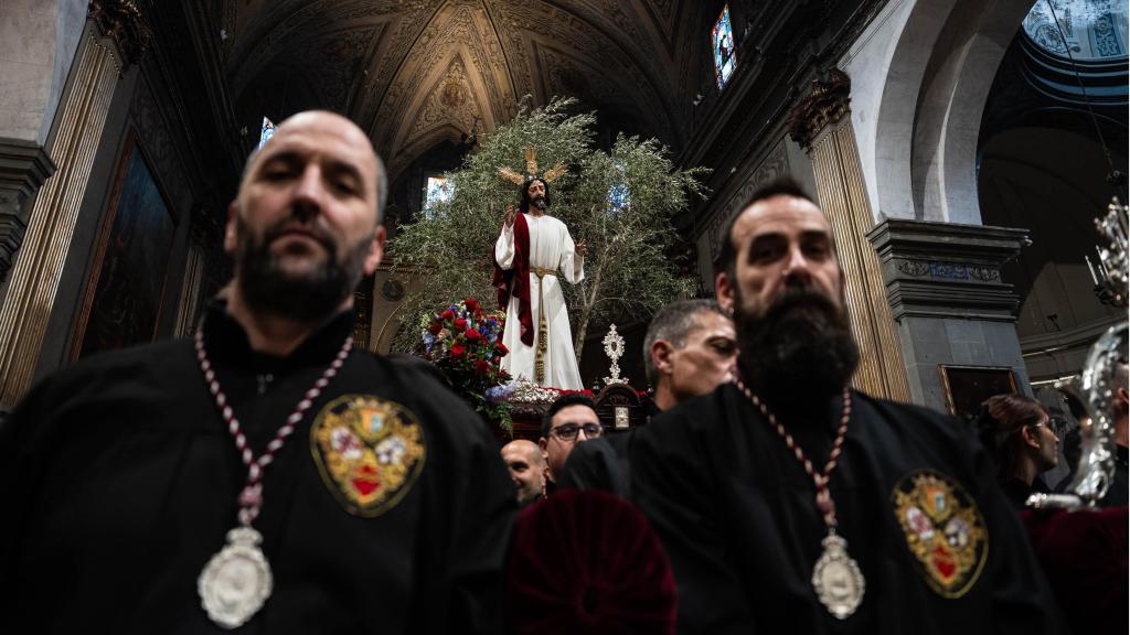 Diversos portadors carreguen el Jesús Cautiu de tornada a la Basílica en el Diumenge de Rams