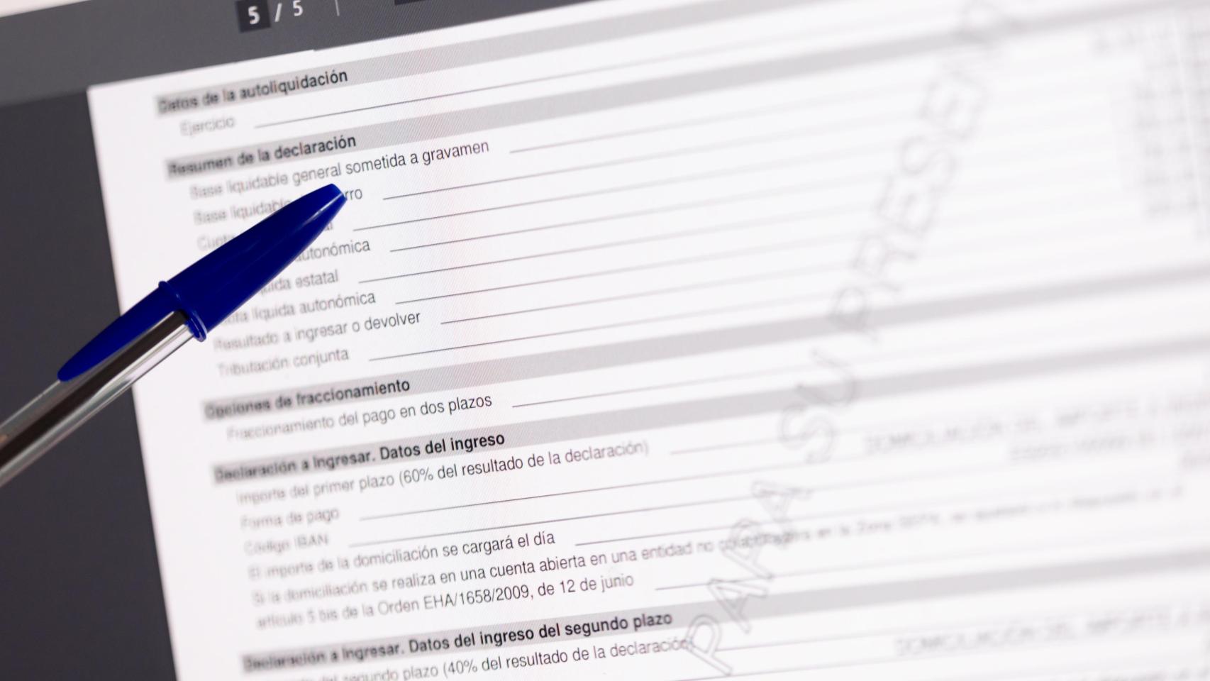 Una persona cumplimenta la declaración de la Renta.jpg