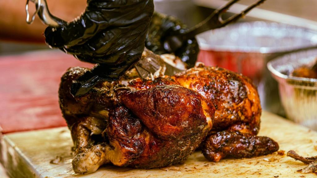 Una persona corta un pollo al horno.jpg