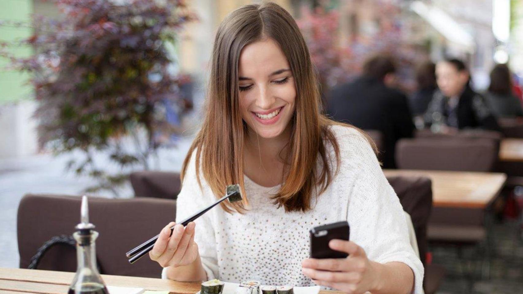Una persona mira el móvil durante la pausa de la comida