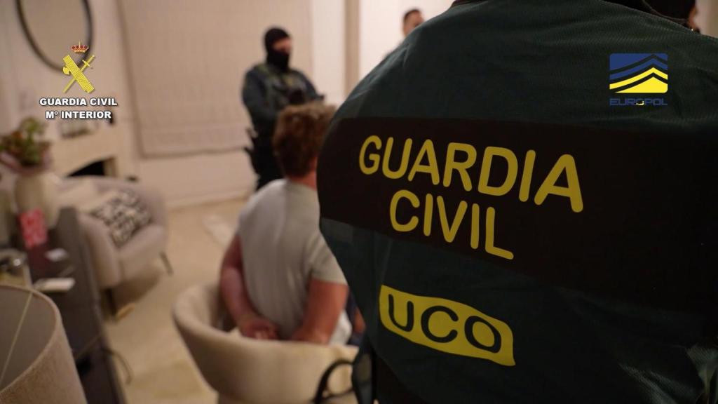 Agente de la UCO de la Guardia Civil con uno de los detenidos del clan Lyons