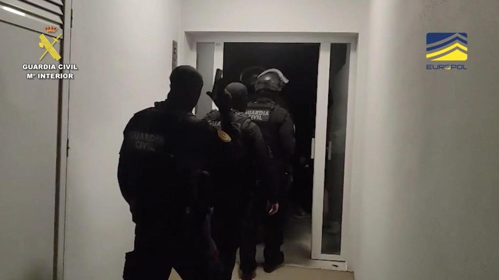 Agents de la Guàrdia Civil irrompent en una de les cases dels detinguts a Espanya