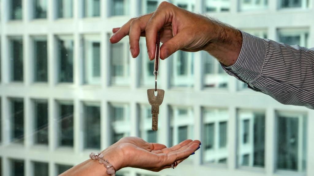 Un propietario entrega las llaves a una inquilina