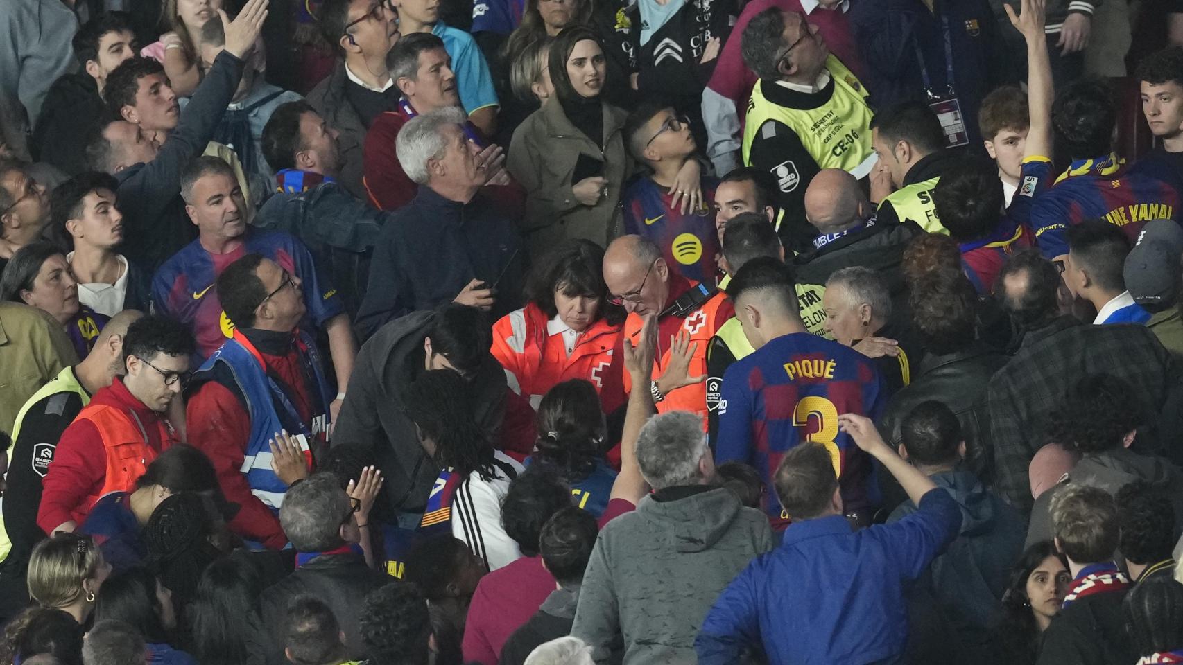 Médicos y vigilantes de seguridad privada atienden a una persona con una parada cardiorrespiratoria durante el Barça-Celta