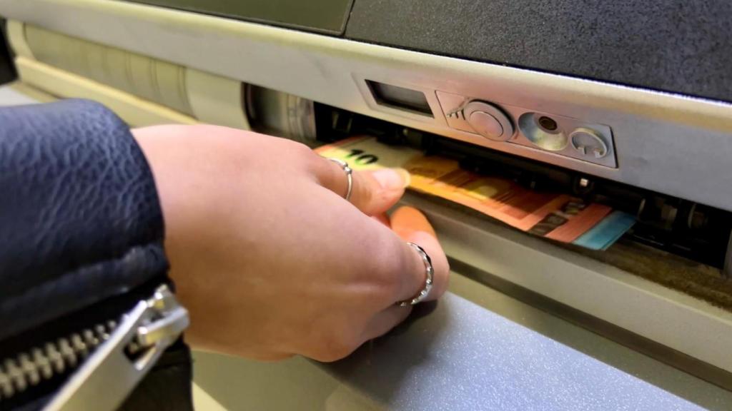 Persona retirando dinero en efectivo de un cajero automático