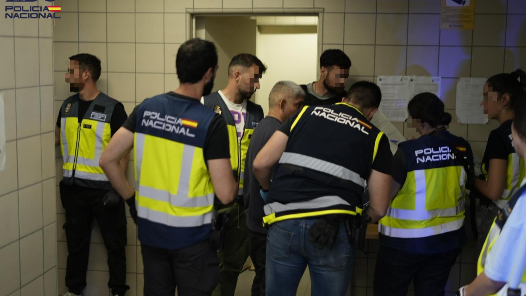 Vario policías acompañan a uno de los extranjeros expulsados
