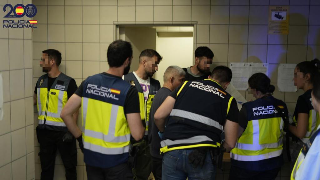 Vario policías acompañan a uno de los extranjeros expulsados