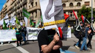 Un manifestante en una protesta de profesores sostiene un cartel para denunciar la pérdida de poder adquisitivo de los docentes