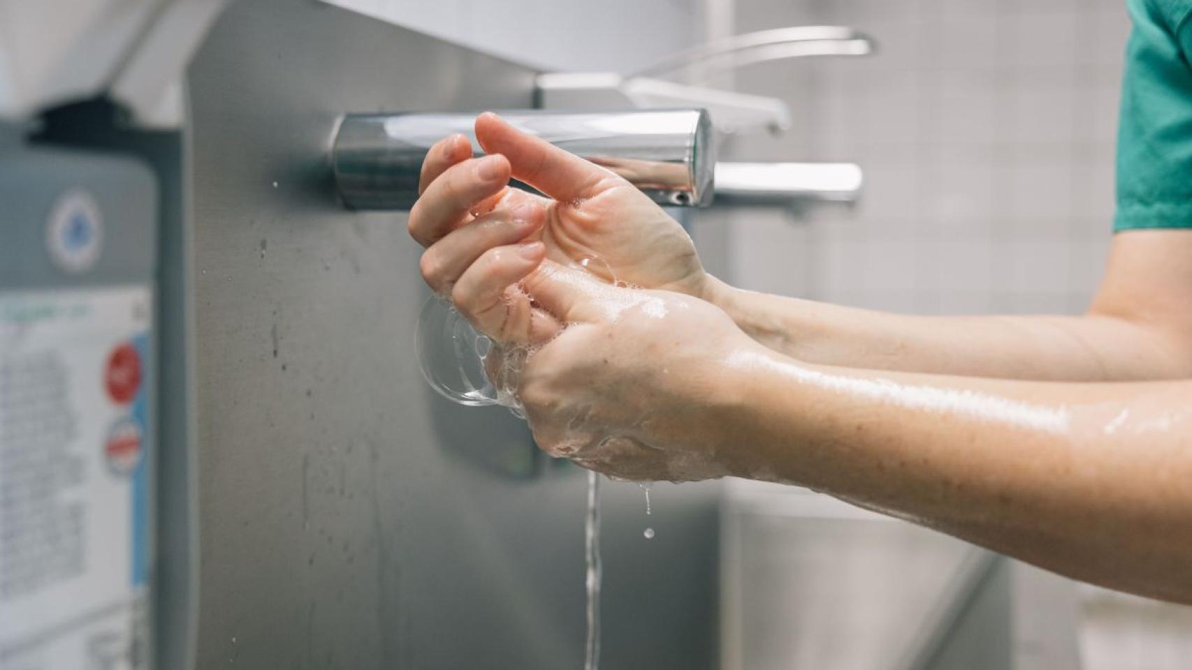 Un sanitario se lava las manos antes de tocar a un paciente hospitalario