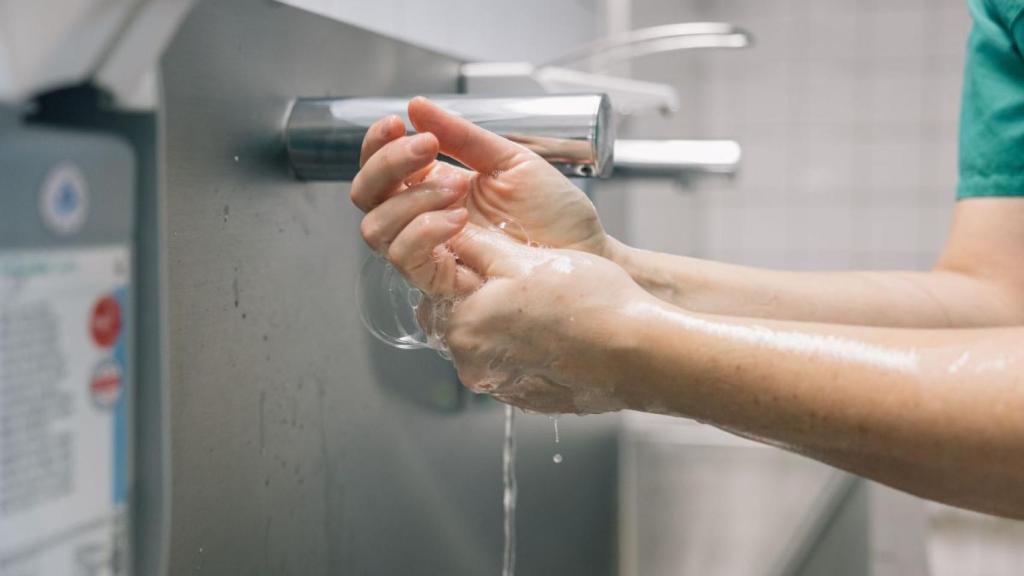 Un sanitario se lava las manos antes de tocar a un paciente hospitalario