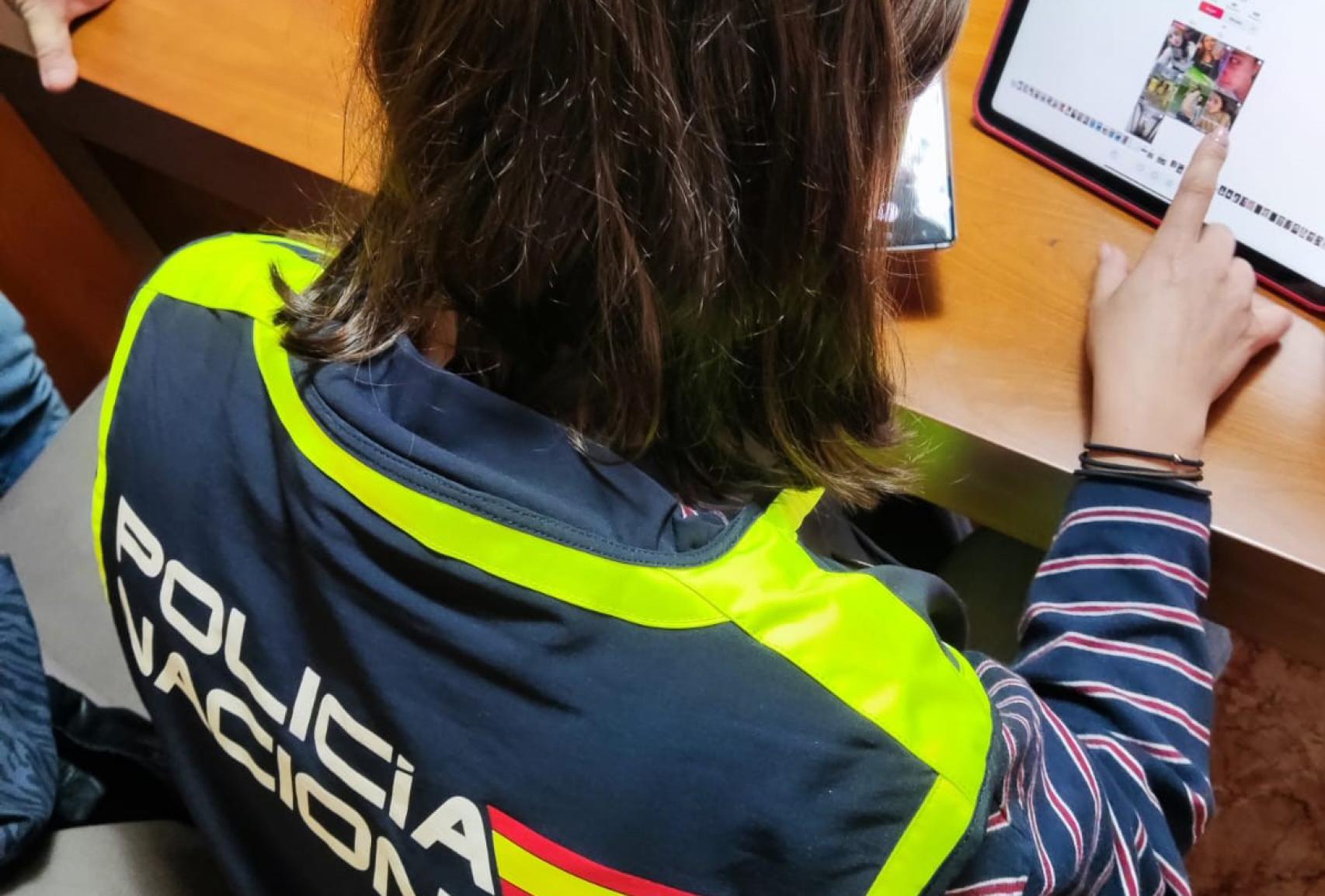 Agent de la Policia Nacional revisa el contingut trobat a l'ordinador del detingut
