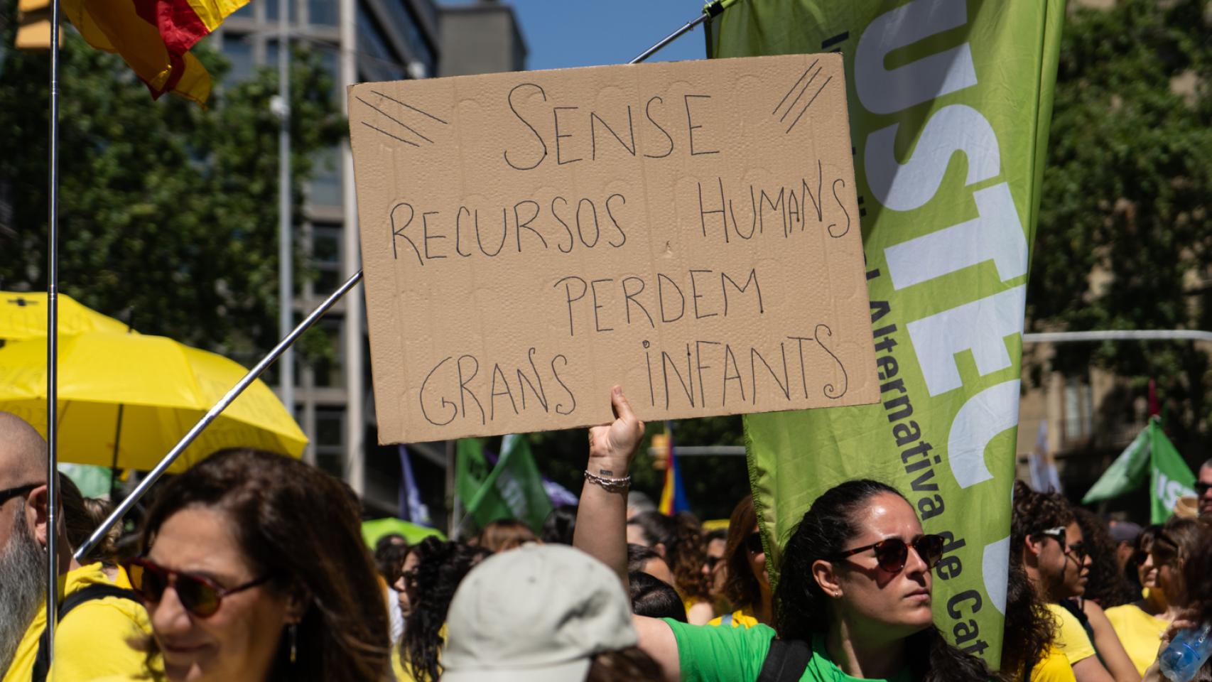 Una docente sostiene un cartel durante una huelga educativa en Barcelona