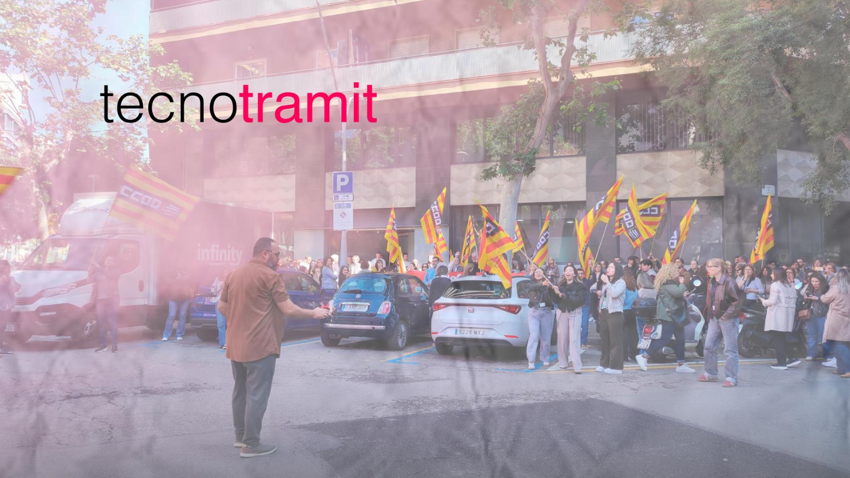 Trabajadores concentrados frente a la sede de Tecnotramit en la calle Casp de Barcelona, junto al logotipo de la compañía