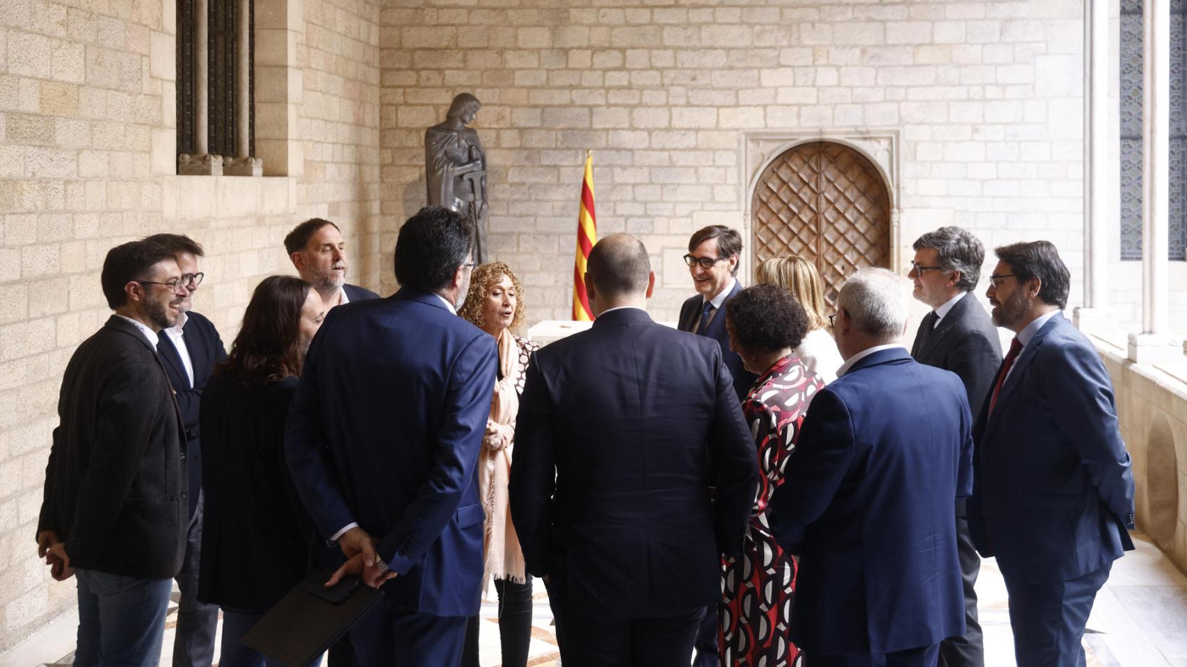 El presidente catalán, Salvador Illa, y el líder de ERC, Oriol Junqueras, conversan animadamente con altos cargos de sus respectivos partidos tras firmar su pacto sobre los presupuestos de la Generalitat 2026