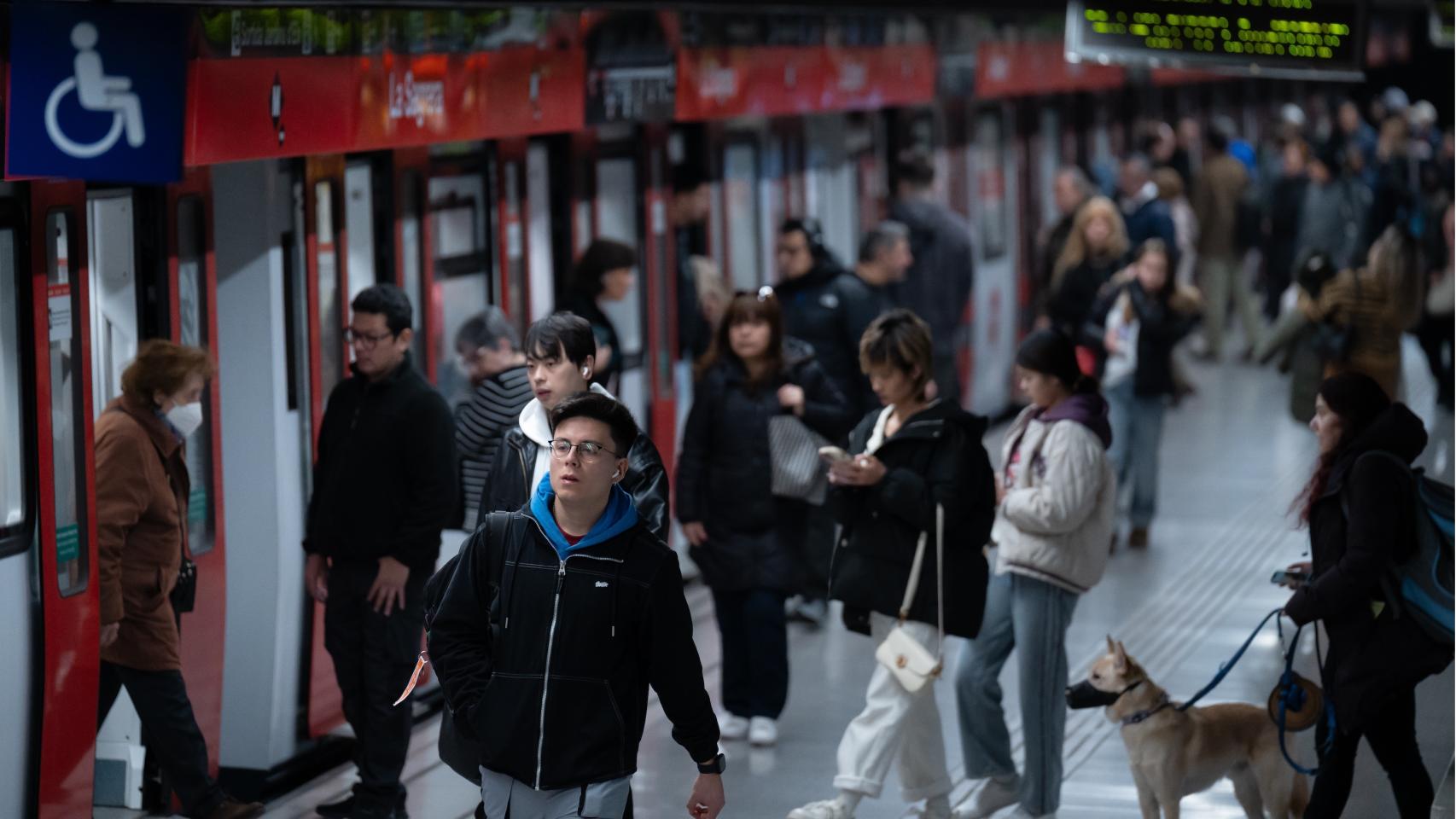 Varias personas salen y entran a un tren en un andén del Metro de Barcelona