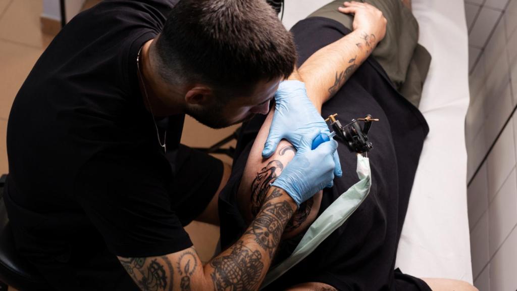 Hombre tatuando con guantes