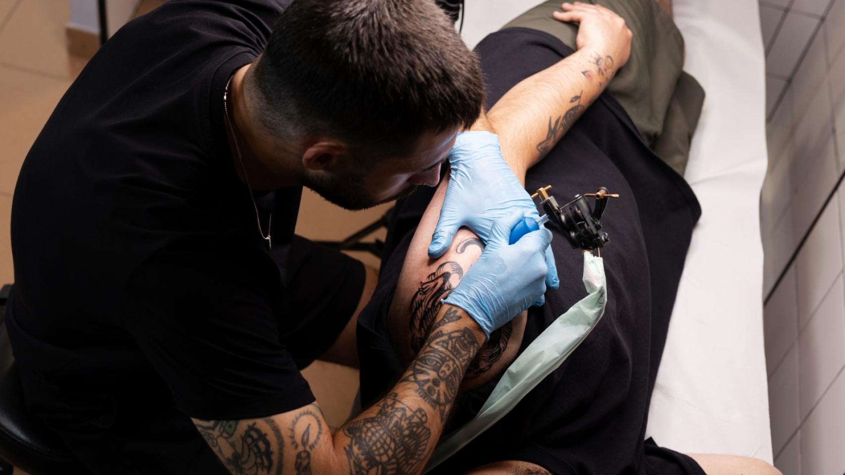 Hombre tatuando con guantes