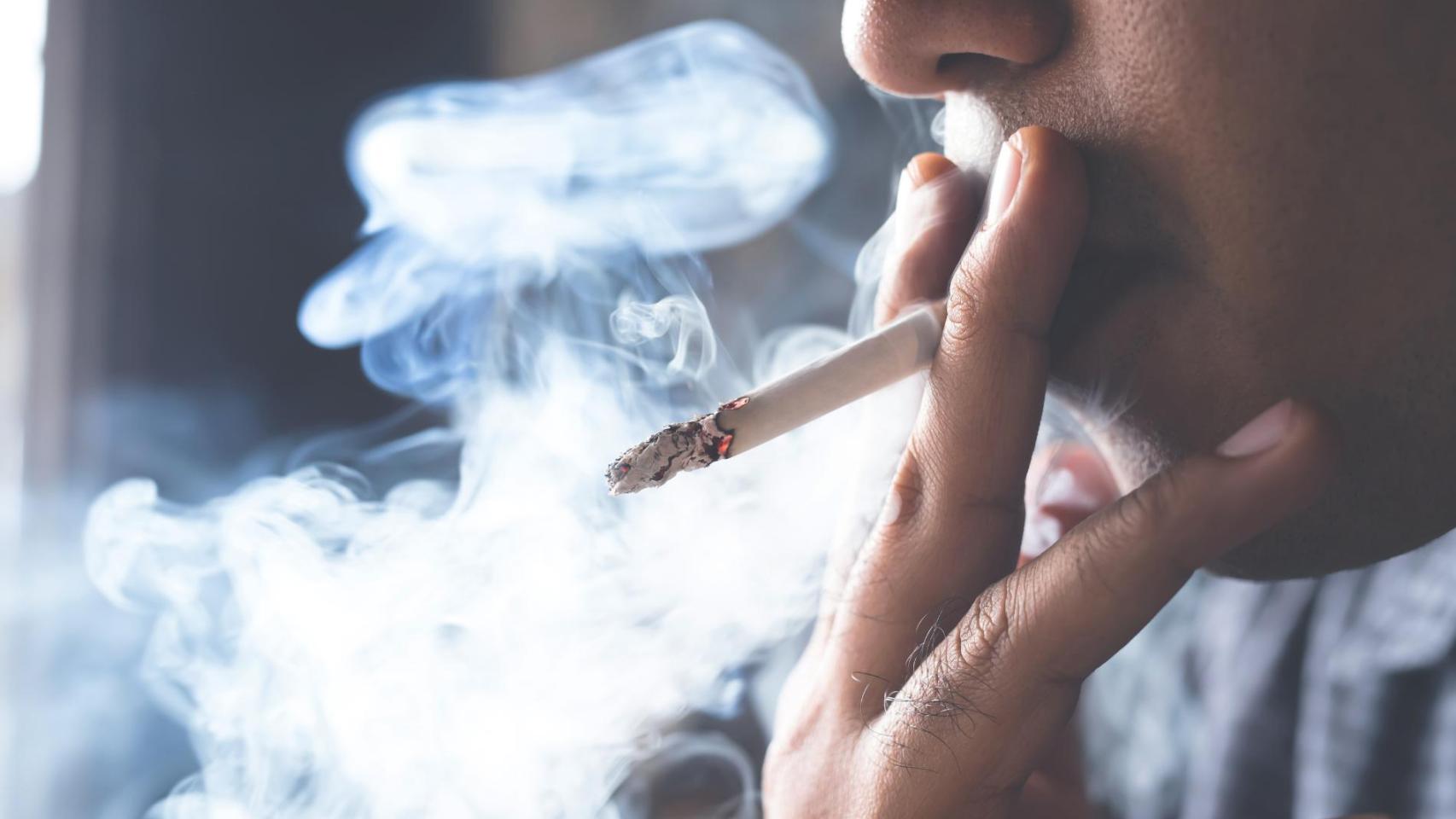 Persona fumando en una terraza, imagen relacionada con la ley que permite prohibir fumar en viviendas y denunciar a vecinos por el humo