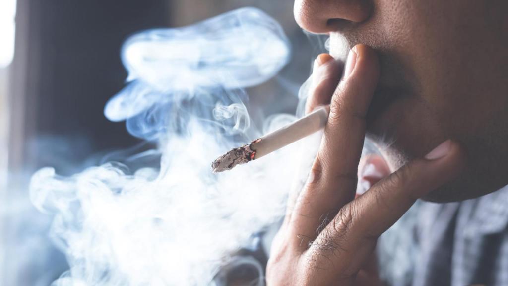 Persona fumando en una terraza, imagen relacionada con la ley que permite prohibir fumar en viviendas y denunciar a vecinos por el humo
