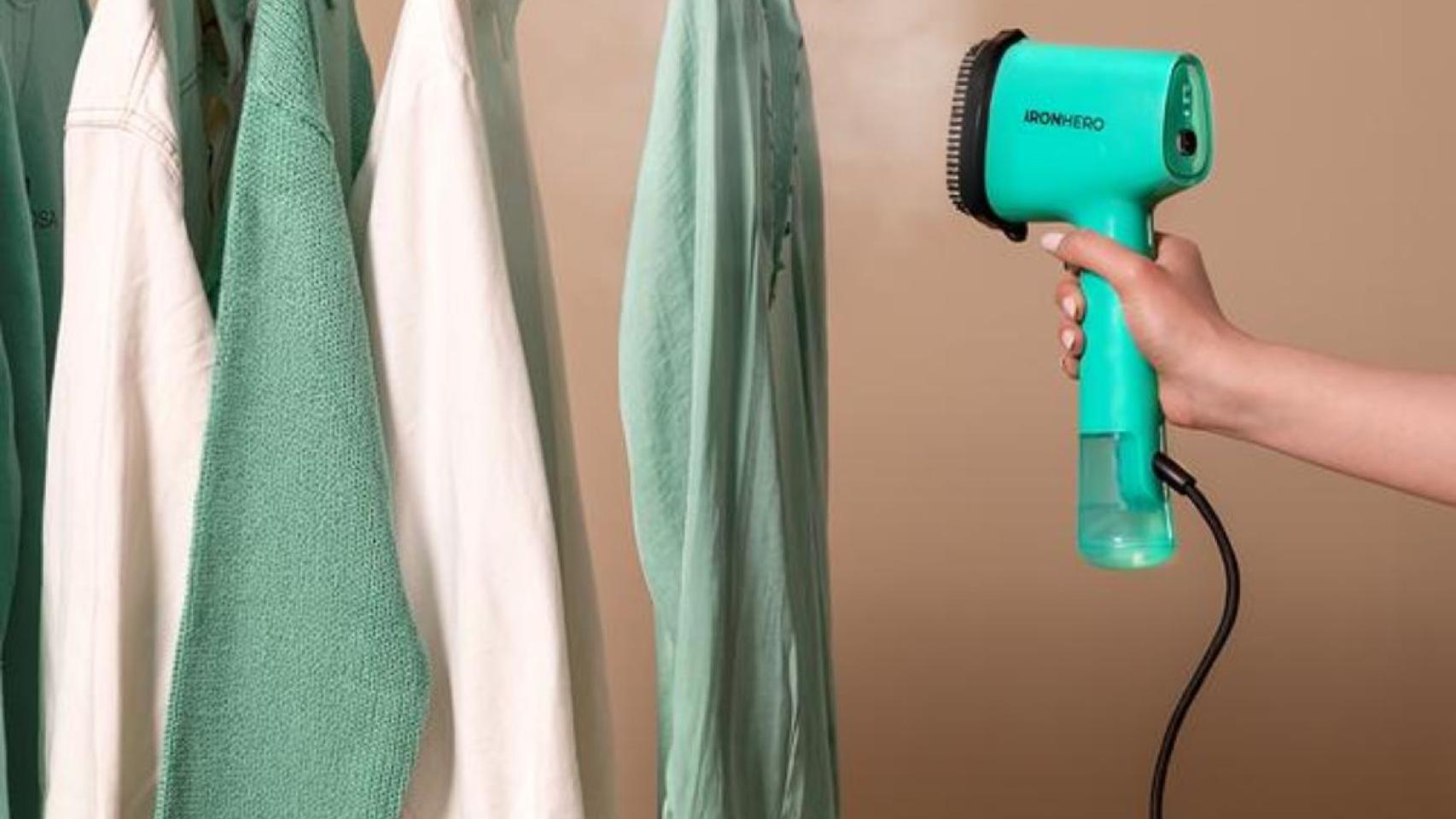 Imagen de un colgador con ropa en tonos blancos y verdes y un secador verde.jpg